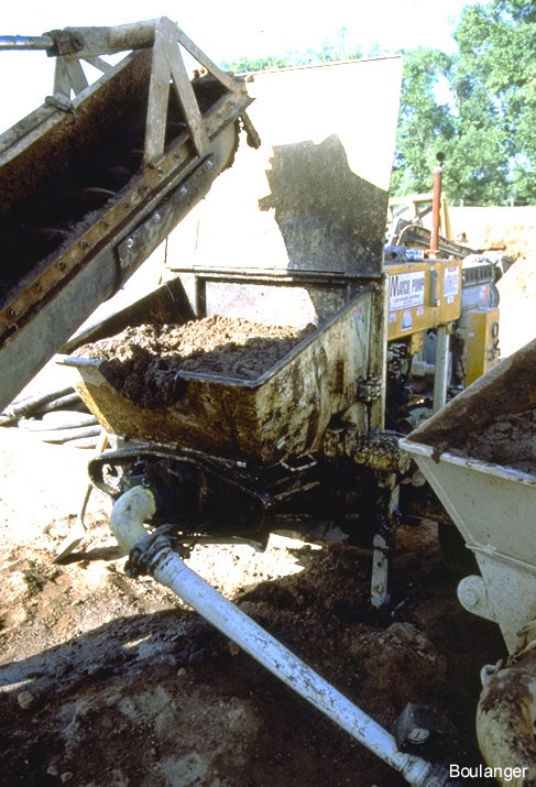 Grout is placed in the hopper of the pump. (Courtesy of Dr. Ross Boulanger, UC Davis). Grout is placed in the hopper of the pump. (Courtesy of Dr. Ross Boulanger, UC Davis).