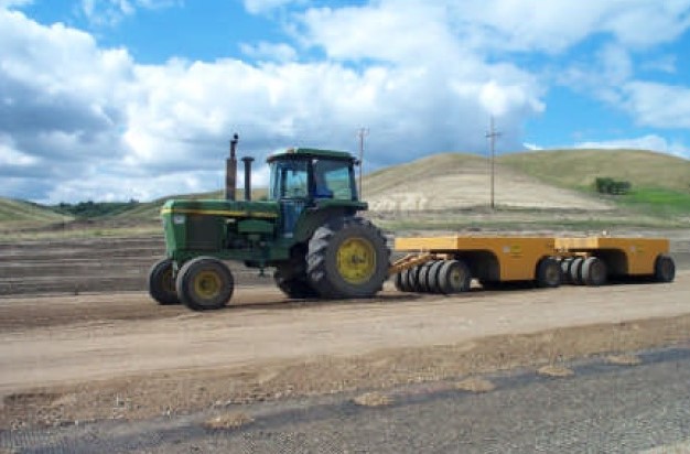 Compaction of base material on top of the geogrid. Courtesy of the North Dakota DOT. Compaction of base material on top of the geogrid. Courtesy of the North Dakota DOT.