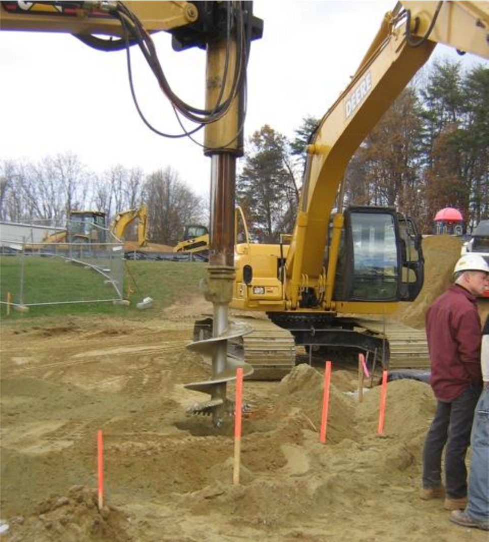 Pre-drilling of hole for rammed aggregate pier installation. (Photograph courtesy of GeoStructures, Inc.) Pre-drilling of hole for rammed aggregate pier installation. (Photograph courtesy of GeoStructures, Inc.)
