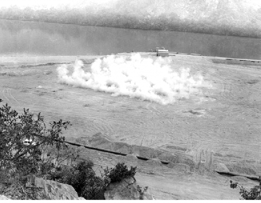 Surface expression of detonation of many charges for deep densification of loose sand at depth.(Photograph from Montreal Engineering Co. Jebba Dam project file, courtesy of AMEC)