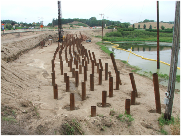 Photograph of steel pipe piles placed to support a load transfer platform as part of an embankment widening project.