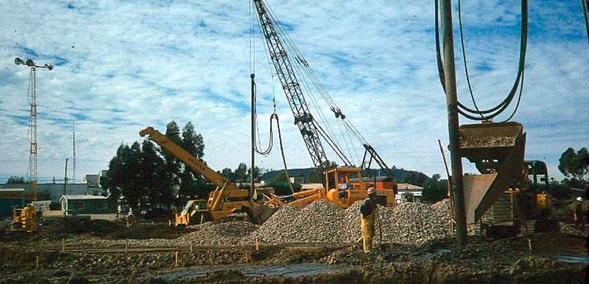 Photograph showing stone column construction using a vibratory probe. Aggregate is being place at the top of the probe location.
