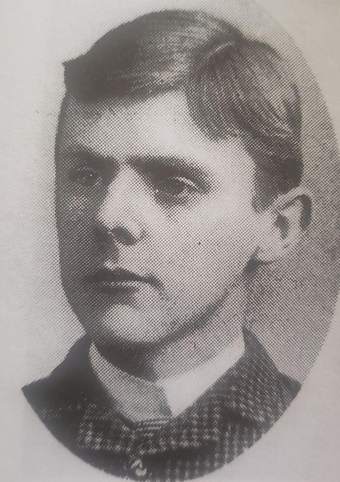 Sepia-toned photograph of John Parke as a student. He is clean-shaven and wearing a checked coat.
