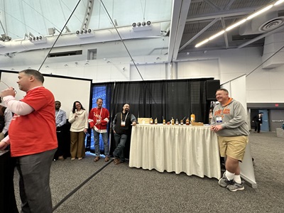 Matt Evans stands by a table bearing bottles of hot sauce