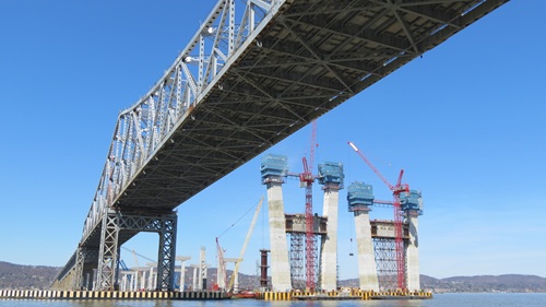 Underside of old Tappan Zee bridge viewed from river. New piles stand to the right.