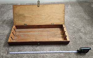Photo of opened wood box next to a tape measure