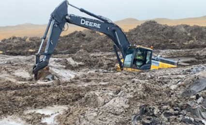Photograph of a excavator buried in mud