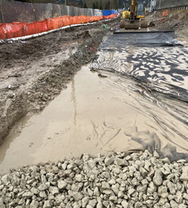 A section of unstabilized aggregate with geotextile separation fabric failing into the subgrade soils