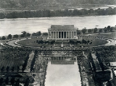 Black and white aerial photograph of Lincoln Memorial. Thick crowds of people are assembled on the Memorial's steps and across the street.